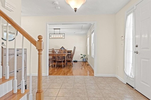 foyer entrance with light tile patterned floors and a notable chandelier