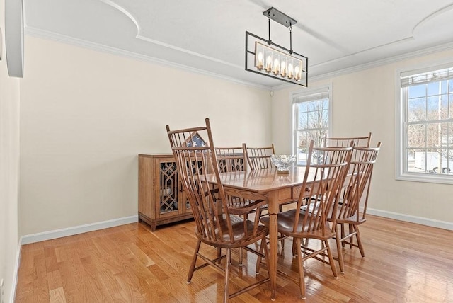 dining area featuring crown molding, an inviting chandelier, and light hardwood / wood-style floors