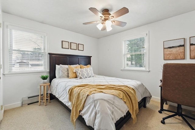 bedroom featuring a baseboard heating unit, carpet, multiple windows, and baseboards