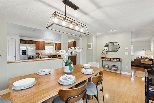 dining area featuring light wood-style floors and baseboards