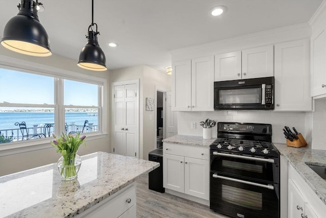 75 Puritan Rd Unit B, Swampscott, MA 01907 - kitchen featuring range with two ovens, decorative backsplash, white cabinetry, light wood-style floors, and decorative light fixtures