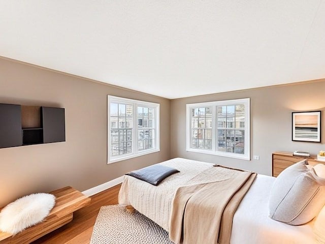 bedroom with baseboards and wood finished floors