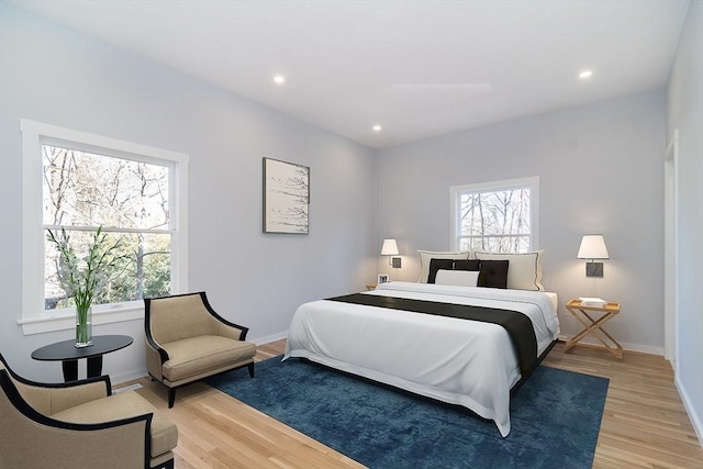 bedroom with hardwood / wood-style flooring and multiple windows