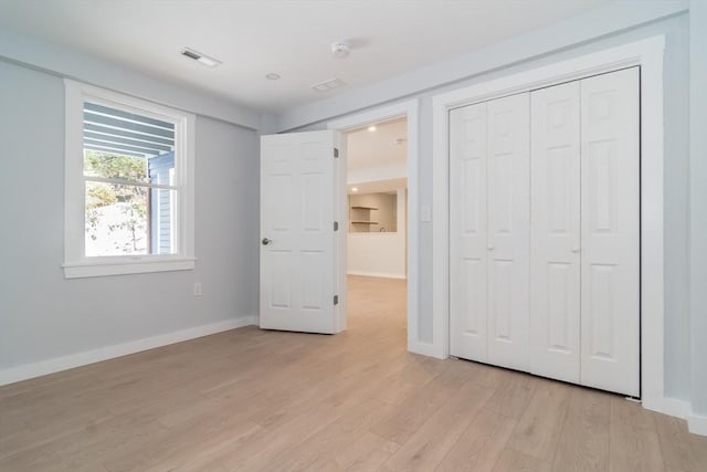 unfurnished bedroom featuring a closet and light hardwood / wood-style floors