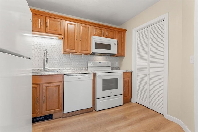 8 Lafayette Park Unit 9, Lynn, MA 01902 - kitchen featuring white appliances, tasteful backsplash, light wood-type flooring, light stone countertops, and brown cabinets