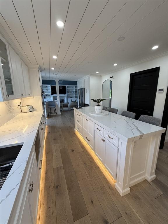 5 Cortland Dr, Hudson, MA 01749 - kitchen with light wood finished floors, open floor plan, white cabinets, glass insert cabinets, and recessed lighting