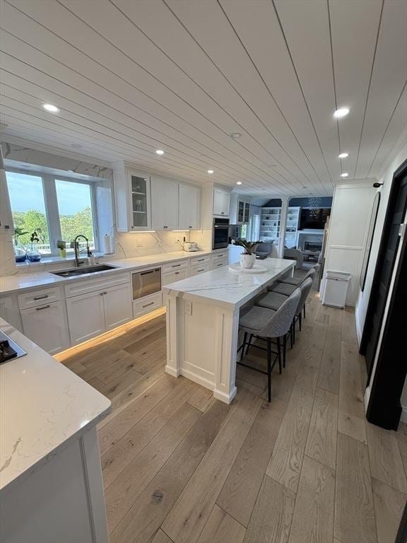 5 Cortland Dr, Hudson, MA 01749 - kitchen with black appliances, light wood-style floors, a sink, white cabinetry, and recessed lighting