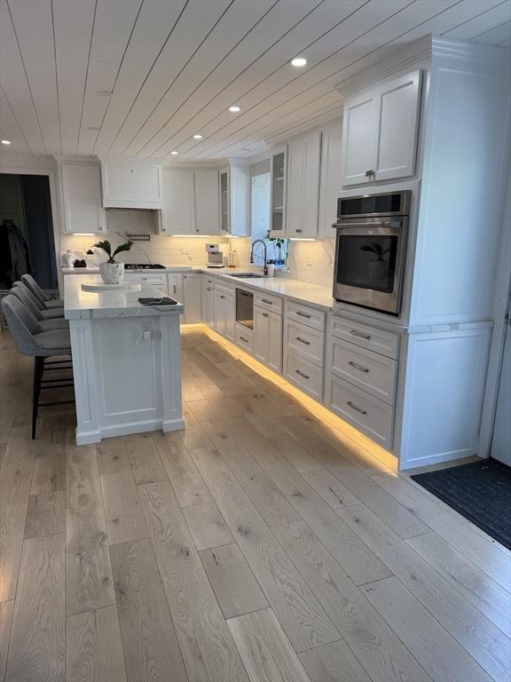 5 Cortland Dr, Hudson, MA 01749 - kitchen featuring stainless steel oven, white cabinets, light wood-type flooring, recessed lighting, and a sink