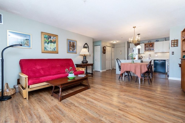11 Church Unit 313, Salem, MA 01970 - living area featuring a chandelier, light wood finished floors, and baseboards
