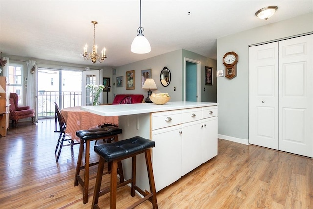 11 Church Unit 313, Salem, MA 01970 - kitchen featuring light wood-style floors, a chandelier, white cabinets, light countertops, and decorative light fixtures