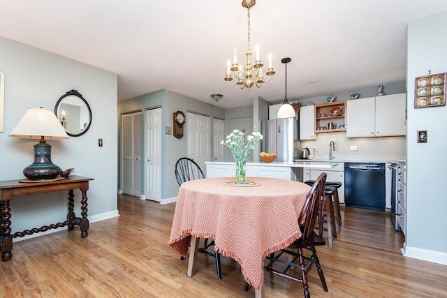 11 Church Unit 313, Salem, MA 01970 - dining area featuring a chandelier, baseboards, and light wood-style flooring