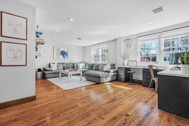 living area with light wood-style flooring, recessed lighting, visible vents, and baseboards