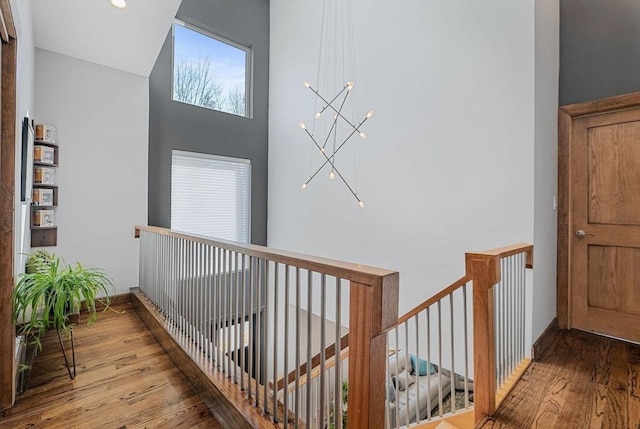 corridor featuring an upstairs landing and wood finished floors