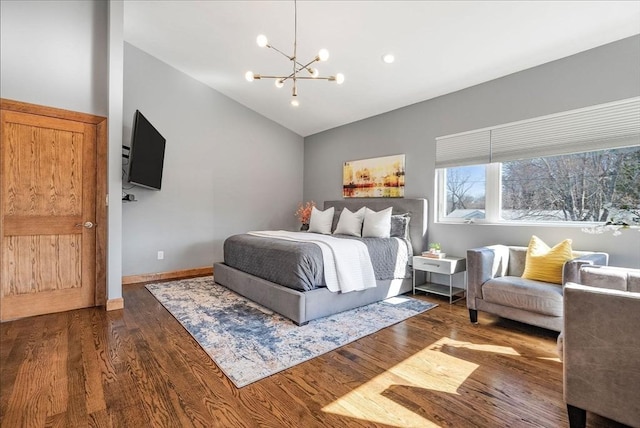 bedroom with an inviting chandelier, vaulted ceiling, wood finished floors, and baseboards