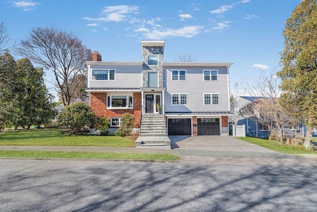 view of front of house featuring driveway, a front lawn, a garage, brick siding, and a chimney