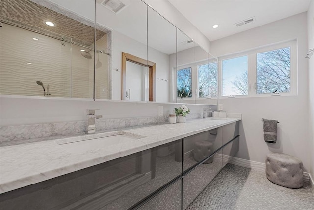 bathroom featuring a sink, visible vents, a shower stall, and double vanity