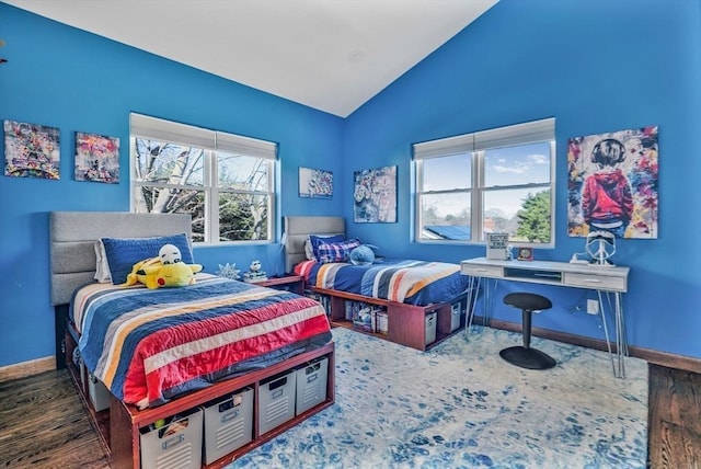 bedroom with lofted ceiling, multiple windows, wood finished floors, and baseboards