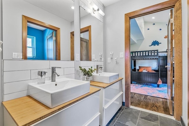 full bathroom with a sink, tasteful backsplash, double vanity, and tile patterned floors