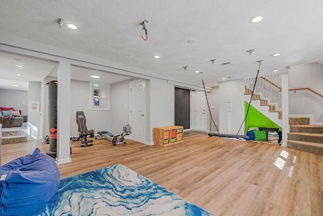 interior space featuring recessed lighting, a textured ceiling, and wood finished floors