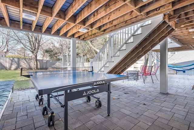 view of patio featuring outdoor dining area, stairs, and fence