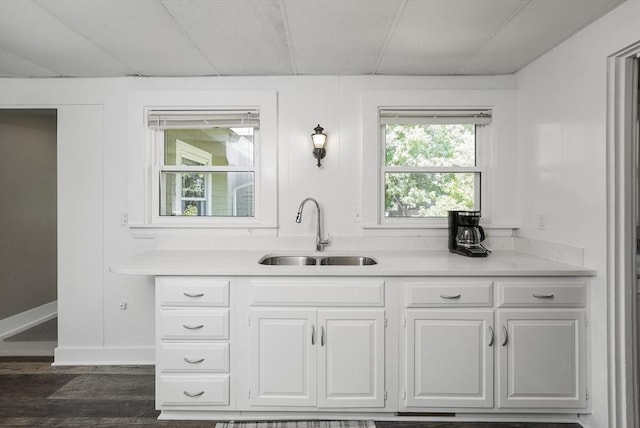 kitchen with sink, dark wood-type flooring, and white cabinets