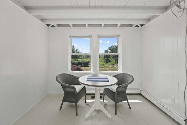 dining space with a baseboard heating unit and beam ceiling