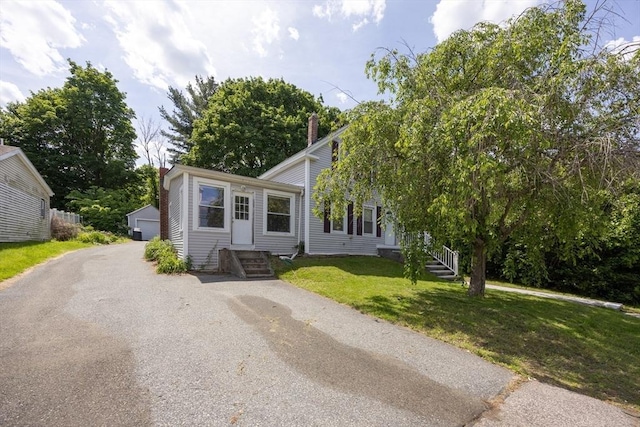 58 Howland St, Marlborough, MA 01752 - view of front of property with a front yard, an outbuilding, a chimney, and a detached garage