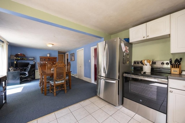 58 Howland St, Marlborough, MA 01752 - kitchen with stainless steel appliances, white cabinets, light tile patterned floors, light colored carpet, and a desk