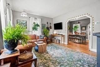 living area with an inviting chandelier, wood finished floors, and a wealth of natural light