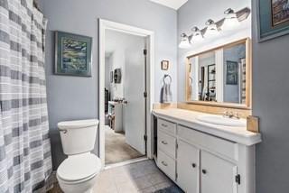 bathroom with vanity, tile patterned floors, toilet, and a shower with curtain