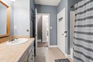 full bathroom with vanity, tile patterned floors, baseboards, and a shower with shower curtain