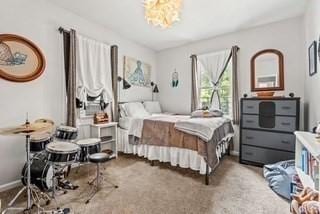 bedroom with baseboards, carpet, and a chandelier