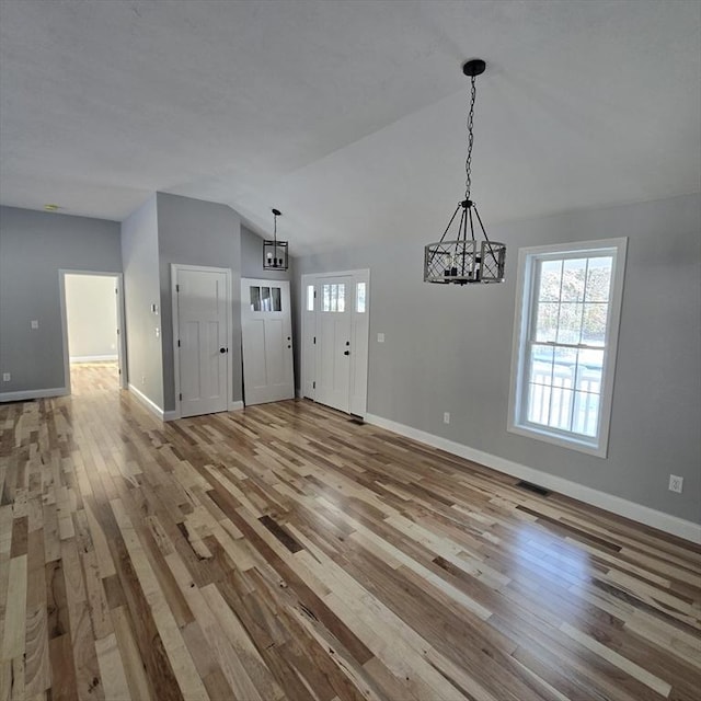 interior space featuring lofted ceiling, a chandelier, and light hardwood / wood-style flooring