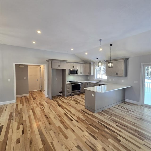 kitchen with sink, gray cabinetry, hanging light fixtures, appliances with stainless steel finishes, and kitchen peninsula