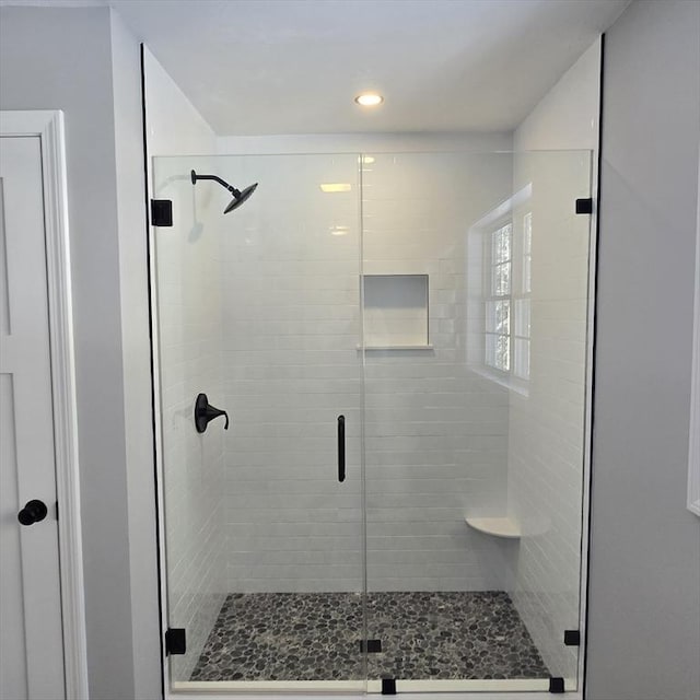 bathroom featuring a shower with door