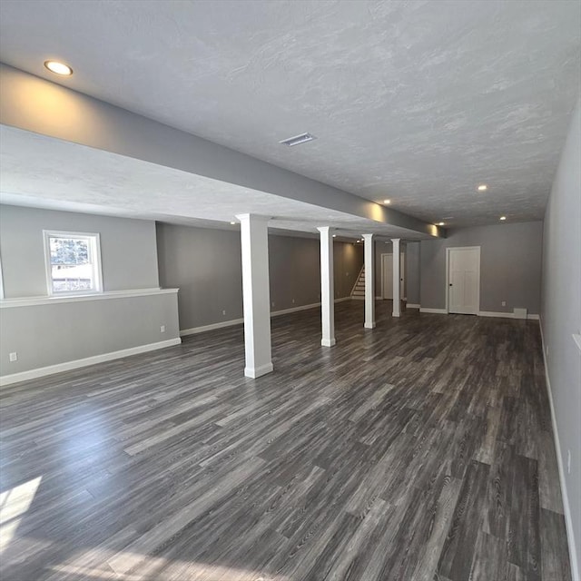 basement featuring dark hardwood / wood-style flooring and a textured ceiling