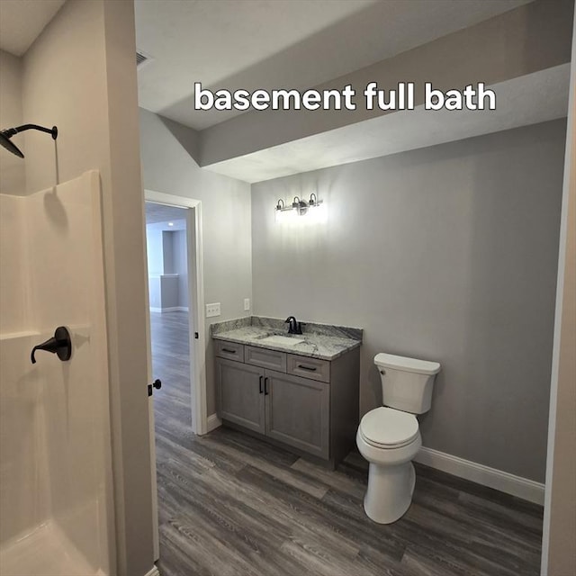 bathroom featuring vanity, toilet, wood-type flooring, and a shower