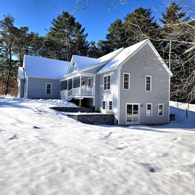 snow covered house with covered porch