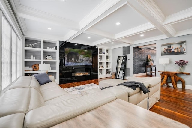 living room featuring a large fireplace, beamed ceiling, wood-type flooring, and built in shelves