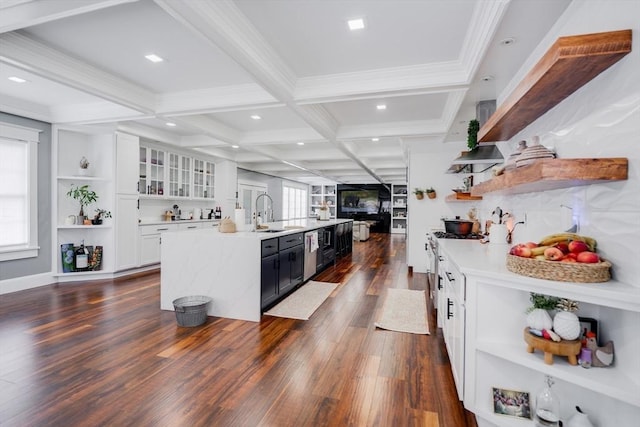 kitchen featuring coffered ceiling, sink, a kitchen island with sink, white cabinets, and beamed ceiling