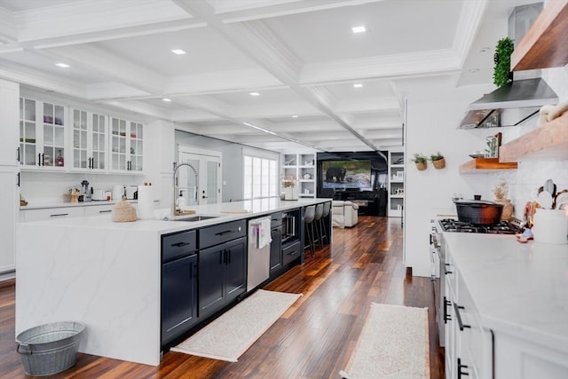 kitchen with white cabinets, sink, and a center island with sink