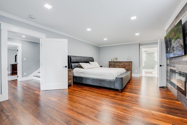 bedroom with wood-type flooring, crown molding, and ensuite bath