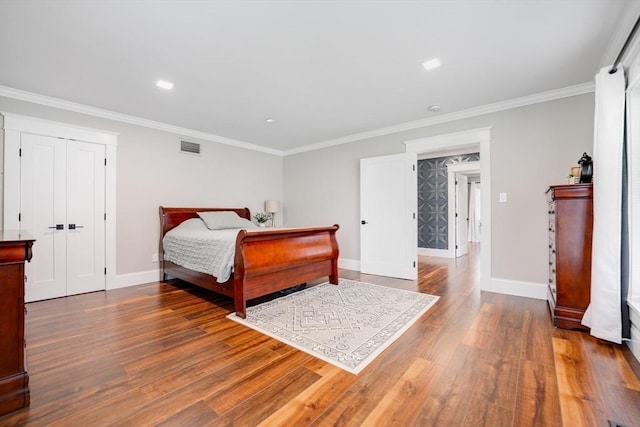 bedroom with wood-type flooring, a closet, and crown molding