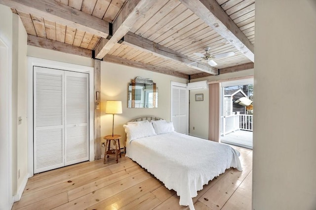 bedroom featuring beamed ceiling, two closets, and wood ceiling