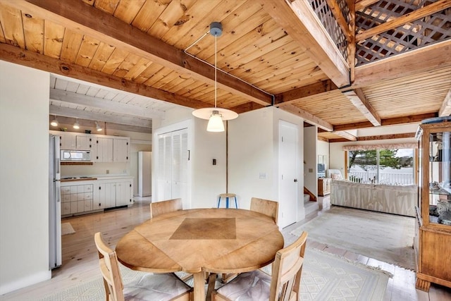 dining area featuring beamed ceiling, light wood finished floors, and wooden ceiling