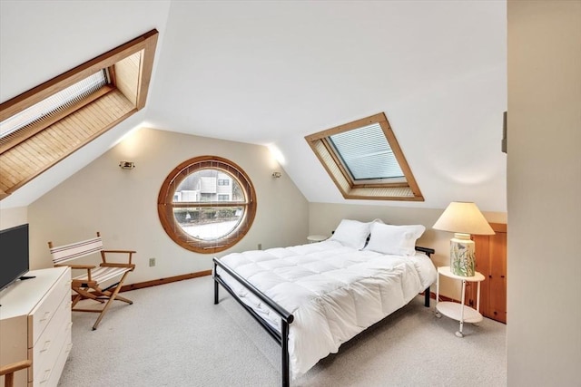 bedroom with light carpet, baseboards, and lofted ceiling with skylight
