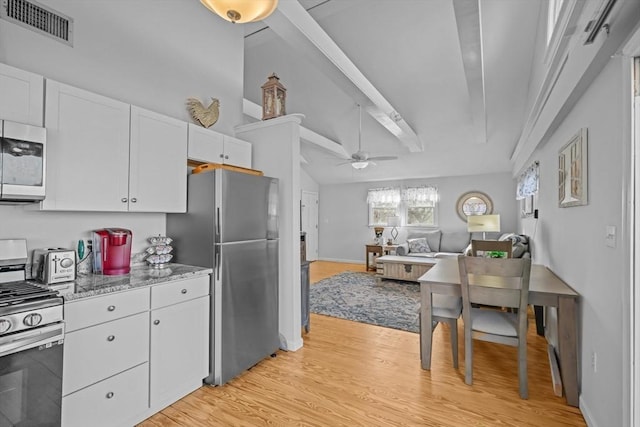 kitchen with visible vents, lofted ceiling with beams, appliances with stainless steel finishes, and white cabinets