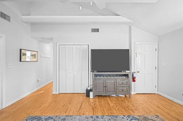 unfurnished living room with visible vents, a ceiling fan, vaulted ceiling with beams, and light wood-type flooring