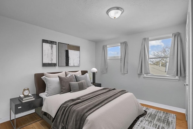 bedroom featuring baseboards and wood finished floors