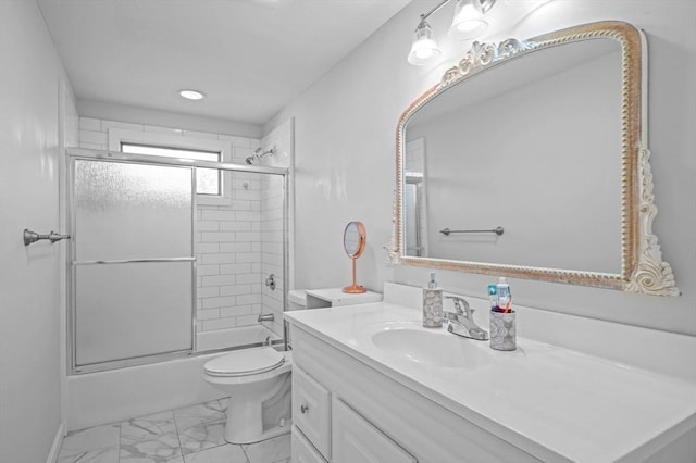 full bathroom featuring vanity, toilet, enclosed tub / shower combo, marble finish floor, and baseboards